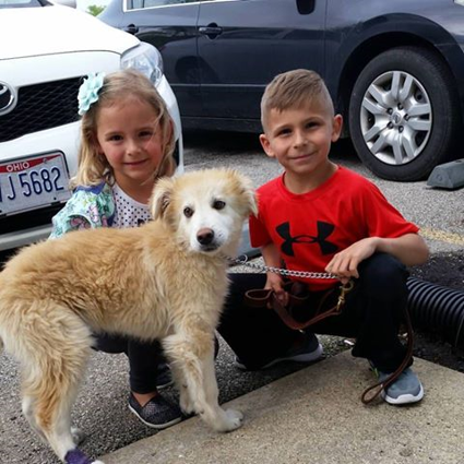 kids sitting with dog